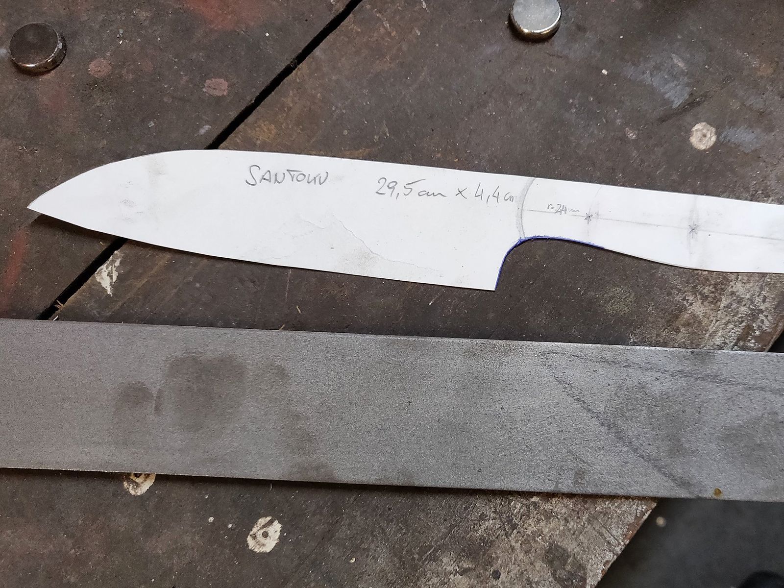 Die Schablone für ein Santoku liegt auf dem Flachstahl